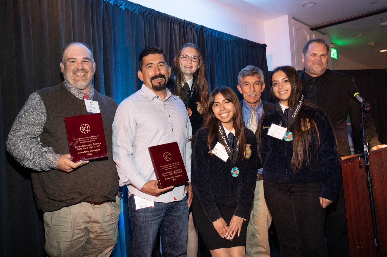 Honorees with their award plaques on stage