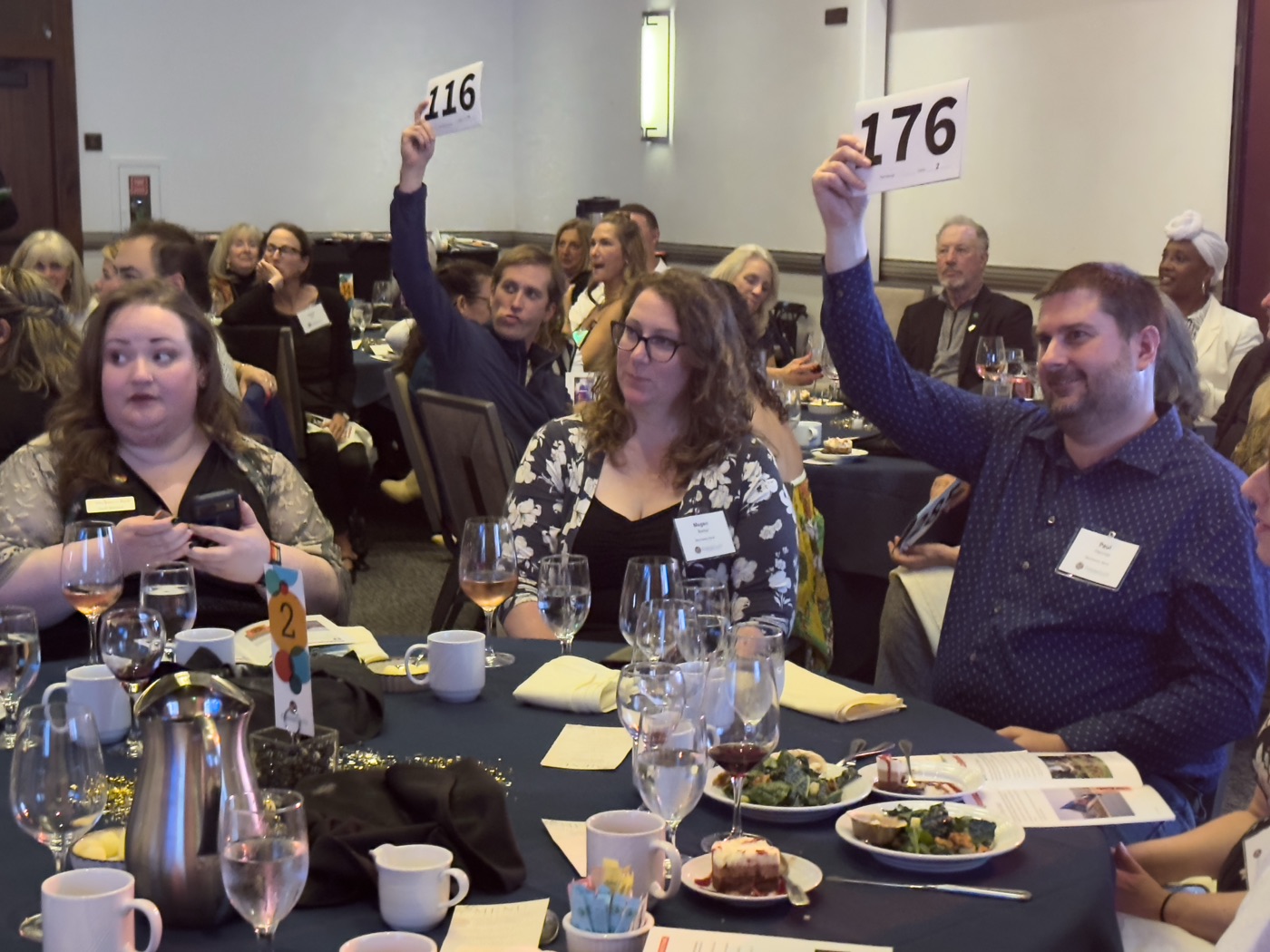 Guests raising bid paddles during the live auction