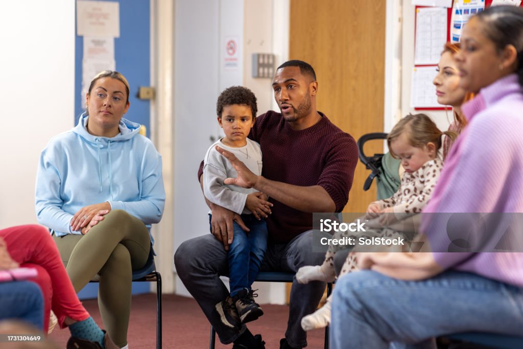 Parents and young children seated together in a circle at a community group session